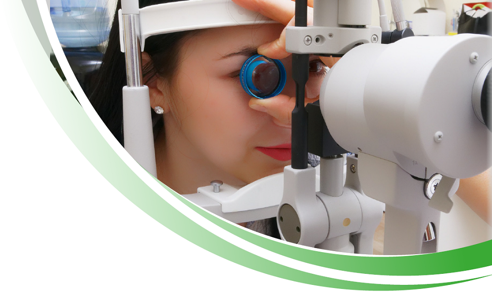 Patientin am Refraktometer Arzt schaut sich die Iris einer Patientin an.